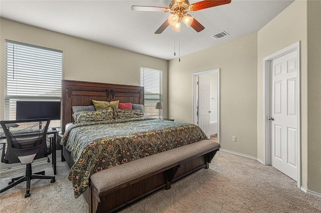 bedroom featuring light carpet, connected bathroom, and ceiling fan