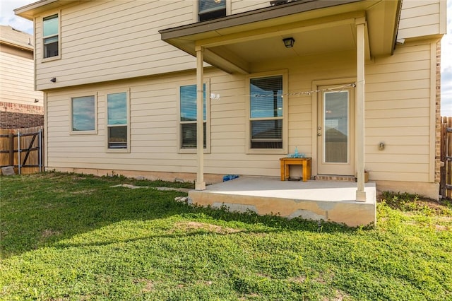 rear view of property featuring a yard and a patio