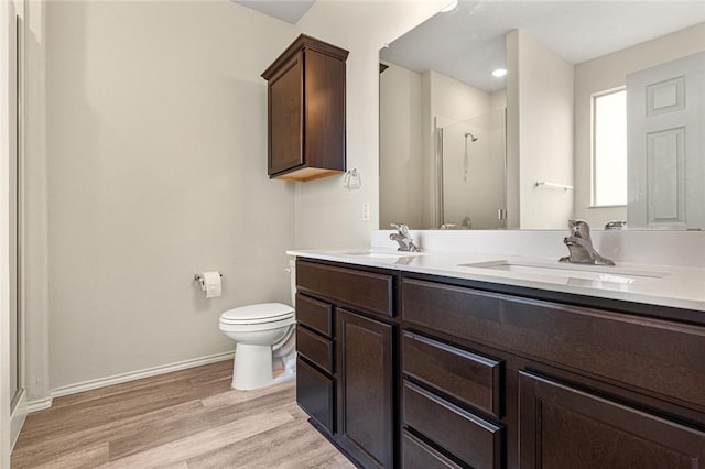 bathroom with vanity, toilet, wood-type flooring, and a shower with door