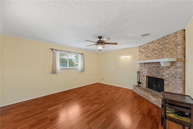 unfurnished living room featuring a fireplace, a textured ceiling, hardwood / wood-style flooring, and ceiling fan