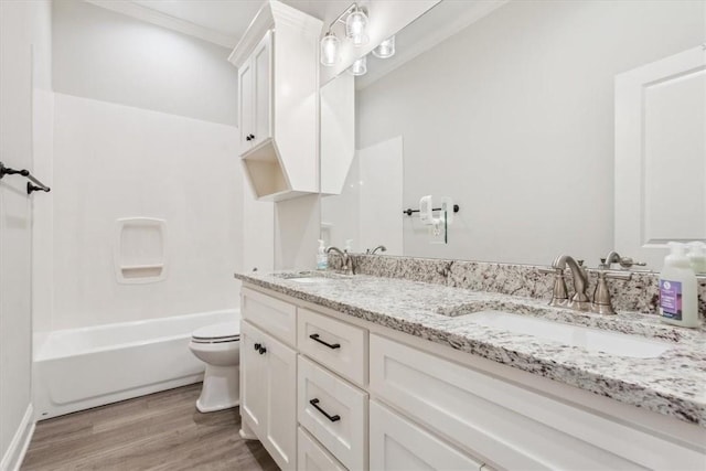 full bath featuring double vanity, wood finished floors, a sink, and toilet