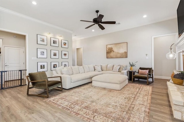 living area with crown molding, recessed lighting, ceiling fan, wood finished floors, and baseboards