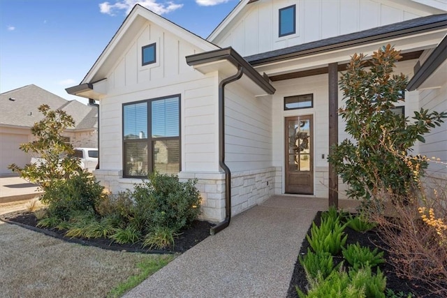 doorway to property featuring stone siding and board and batten siding