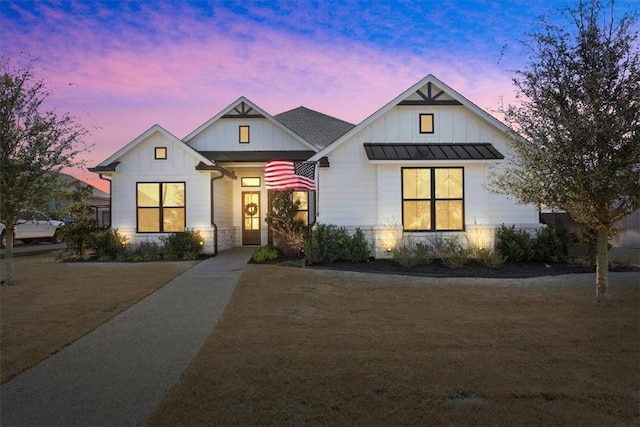 modern farmhouse style home featuring board and batten siding, a standing seam roof, and metal roof