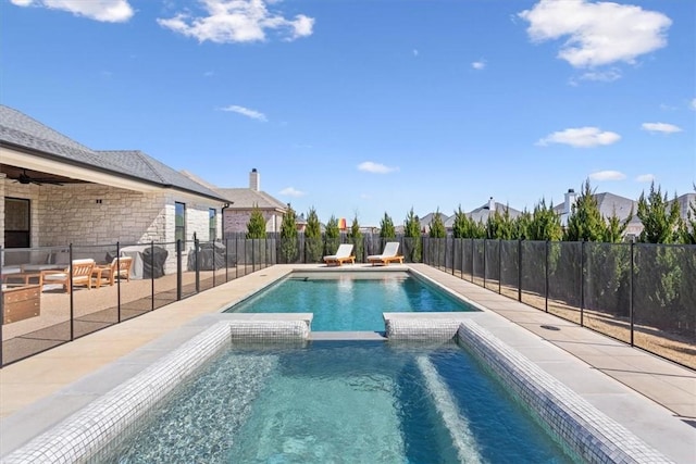 view of pool featuring a pool with connected hot tub, fence, and a patio