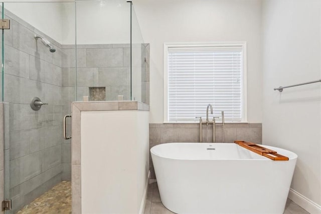 full bathroom with a stall shower and a freestanding bath