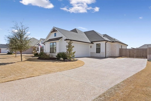 view of front facade with driveway, a shingled roof, stone siding, an attached garage, and board and batten siding