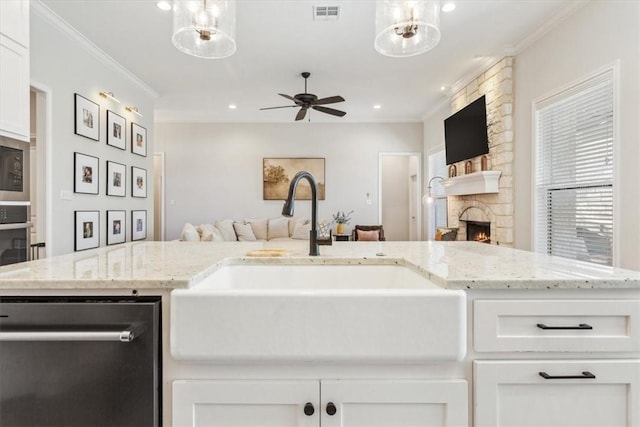 kitchen featuring a fireplace, a sink, visible vents, open floor plan, and dishwasher