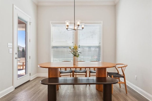 dining area with light wood-style floors, ornamental molding, and baseboards