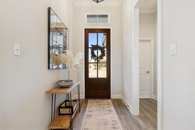 foyer entrance featuring baseboards, wood finished floors, visible vents, and crown molding