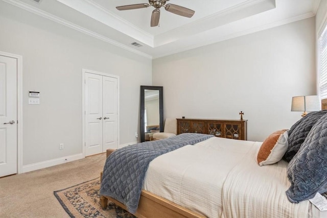 bedroom featuring a raised ceiling, carpet flooring, crown molding, and baseboards