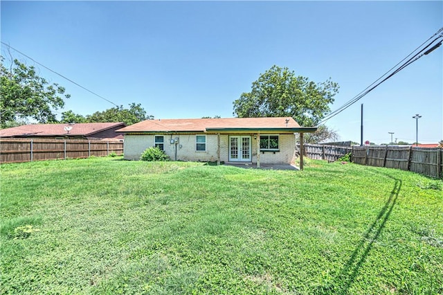 back of property with french doors and a lawn