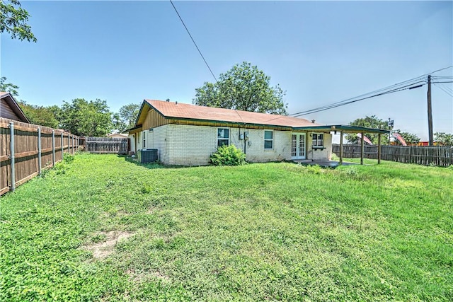 rear view of house with a lawn, french doors, and central AC