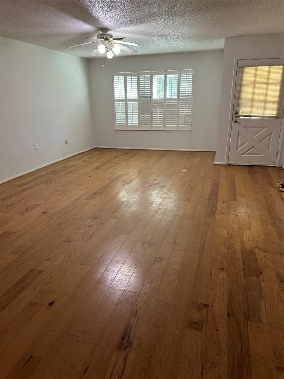 spare room featuring a textured ceiling, light hardwood / wood-style floors, and ceiling fan