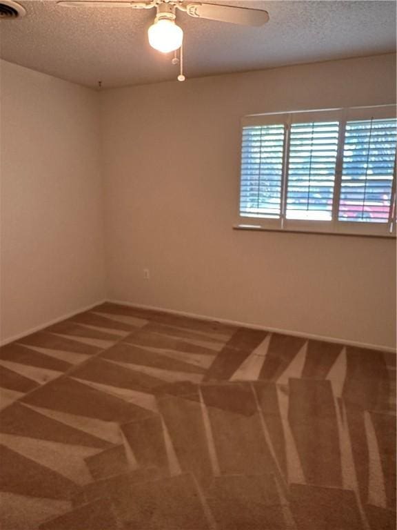 empty room featuring carpet flooring, ceiling fan, and a textured ceiling