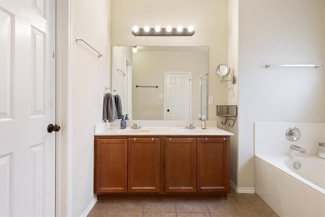 bathroom featuring tile patterned flooring, vanity, and a tub to relax in