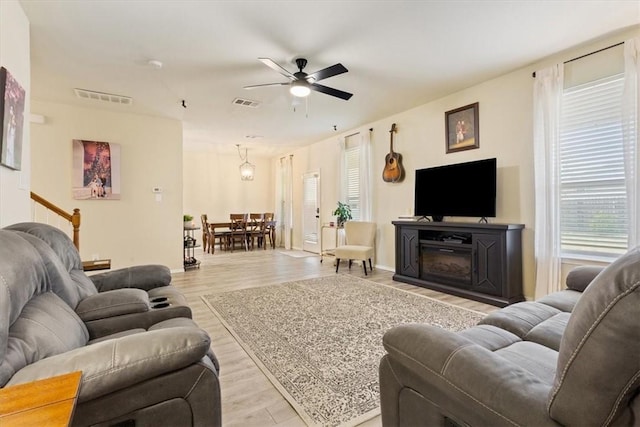 living room with ceiling fan and light wood-type flooring