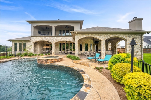 back of house featuring ceiling fan, a pool with hot tub, and a patio