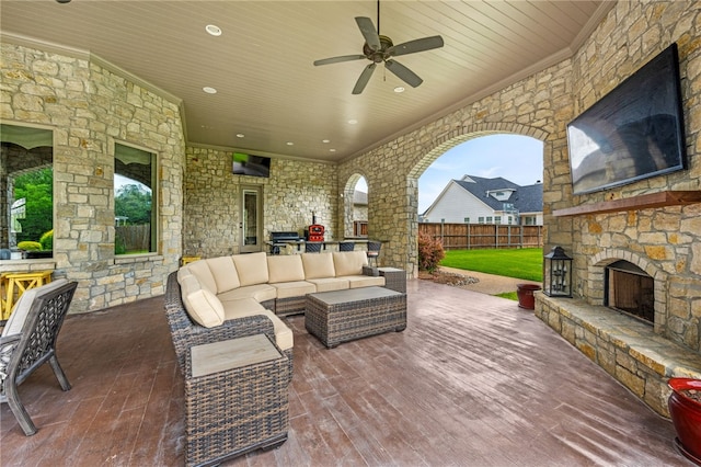 view of patio with an outdoor living space with a fireplace, area for grilling, and ceiling fan