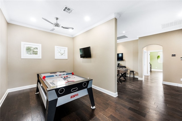 game room with ceiling fan, dark wood-type flooring, and ornamental molding