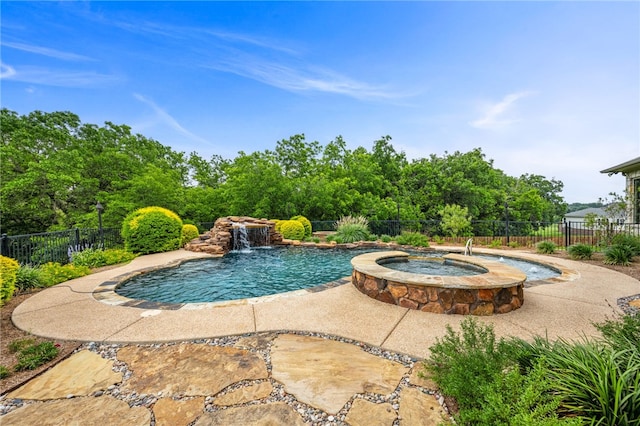 view of pool featuring pool water feature and an in ground hot tub