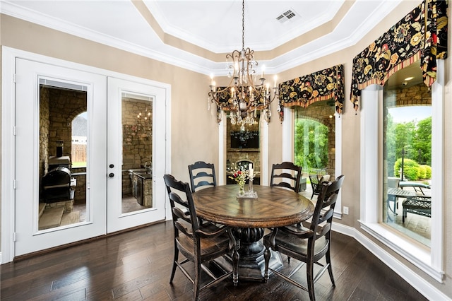 dining space featuring a chandelier, french doors, crown molding, and dark wood-type flooring