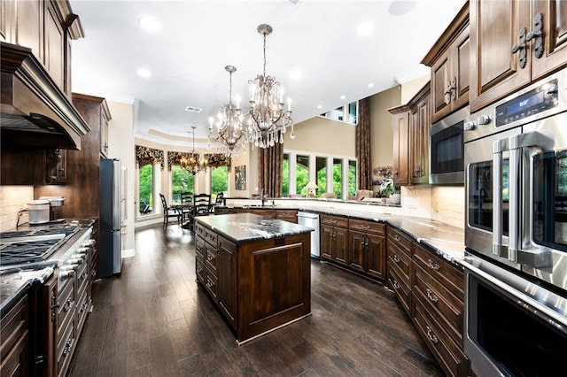 kitchen with dark brown cabinetry, stainless steel appliances, a kitchen island, and dark wood-type flooring