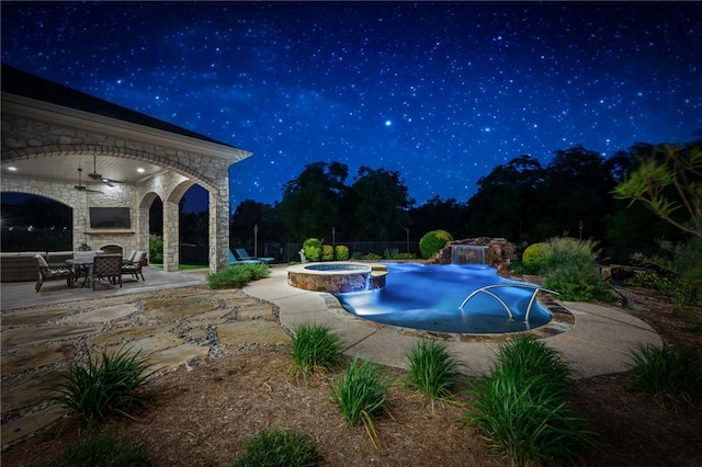 pool at twilight featuring an in ground hot tub, a patio, and ceiling fan