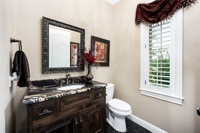 bathroom with plenty of natural light, toilet, and vanity