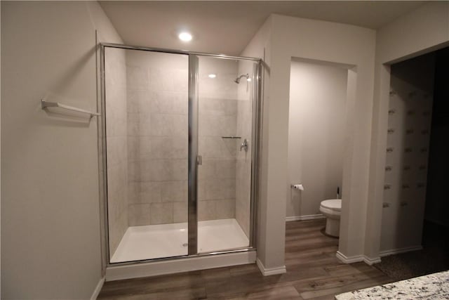 bathroom featuring wood-type flooring, toilet, and walk in shower