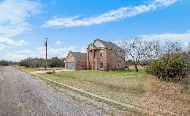 view of front of property featuring gravel driveway, a front yard, a garage, and brick siding