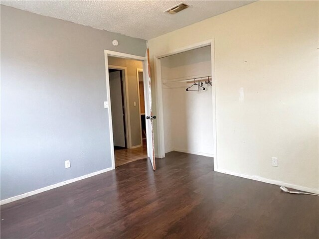 bedroom with a textured ceiling, ceiling fan, and dark wood-type flooring