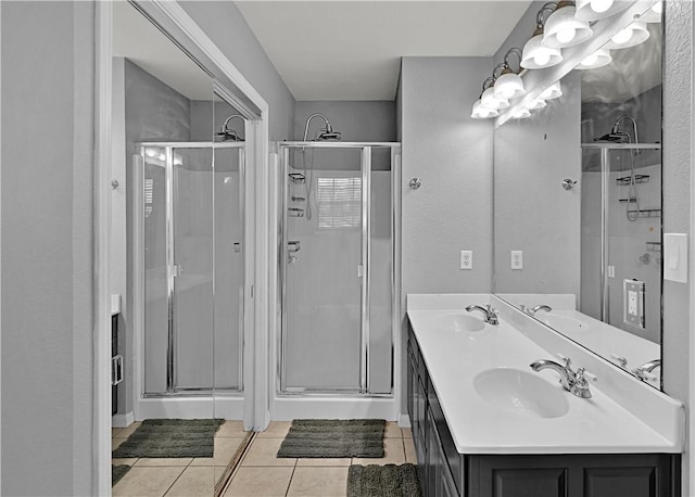 full bath featuring a stall shower, tile patterned flooring, and a sink