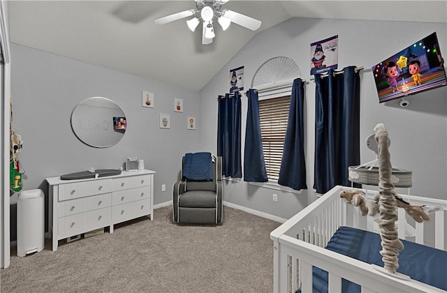 bedroom featuring a ceiling fan, carpet flooring, vaulted ceiling, a nursery area, and baseboards