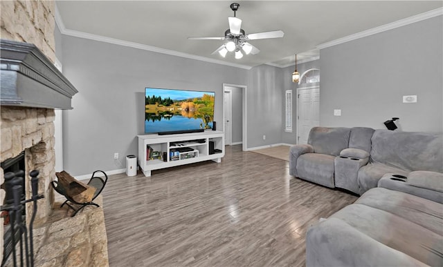 living room with ceiling fan, crown molding, baseboards, and wood finished floors