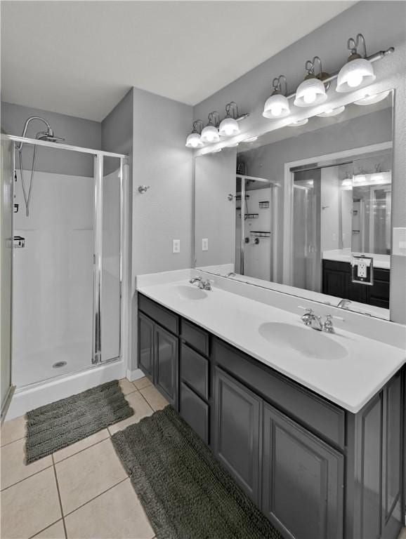 bathroom with a stall shower, a sink, and tile patterned floors