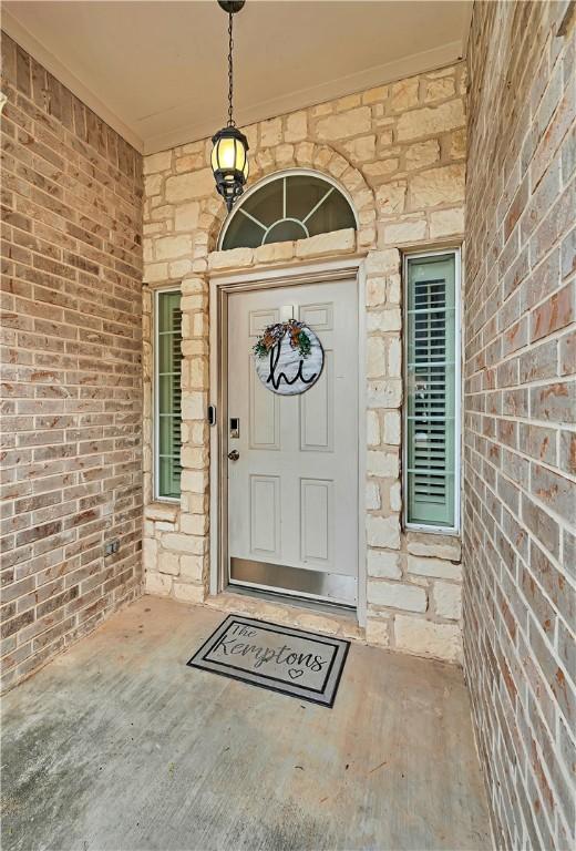 property entrance featuring stone siding and brick siding