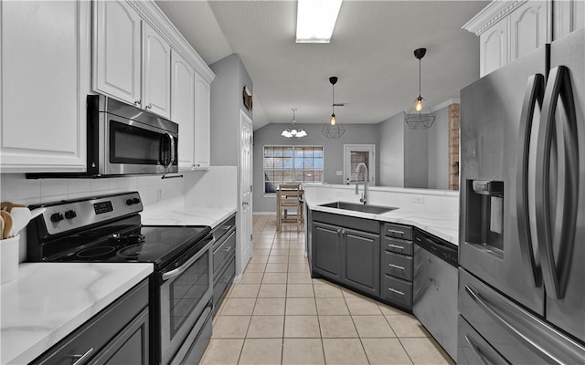 kitchen with white cabinets, light tile patterned floors, stainless steel appliances, and a sink