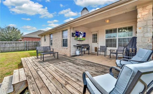 wooden terrace featuring a yard and fence