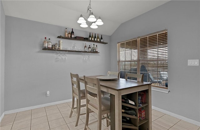 dining room featuring light tile patterned floors, a notable chandelier, lofted ceiling, and baseboards