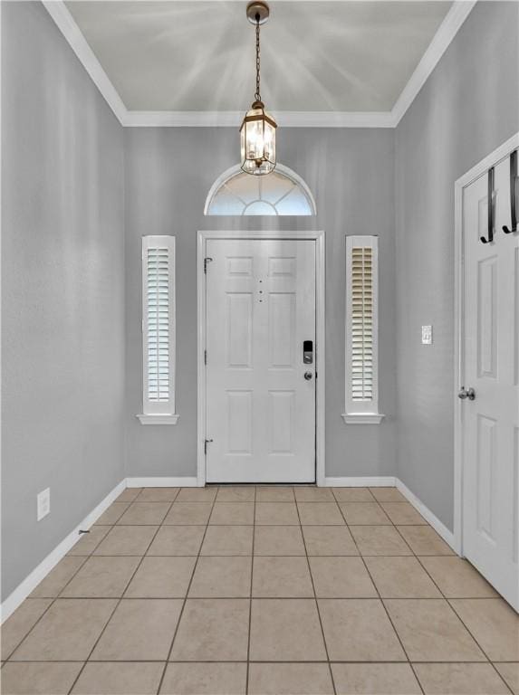 foyer entrance featuring crown molding, baseboards, and light tile patterned floors