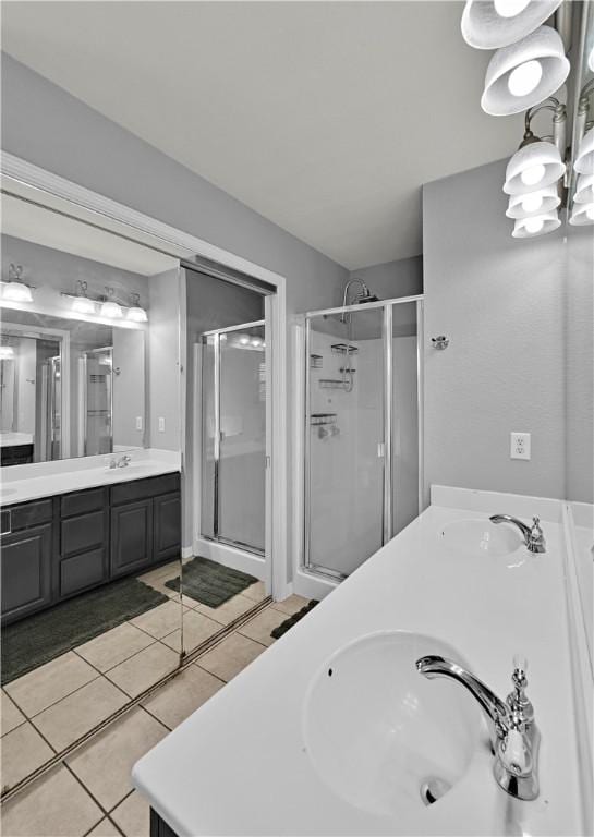 bathroom featuring double vanity, a stall shower, and a sink