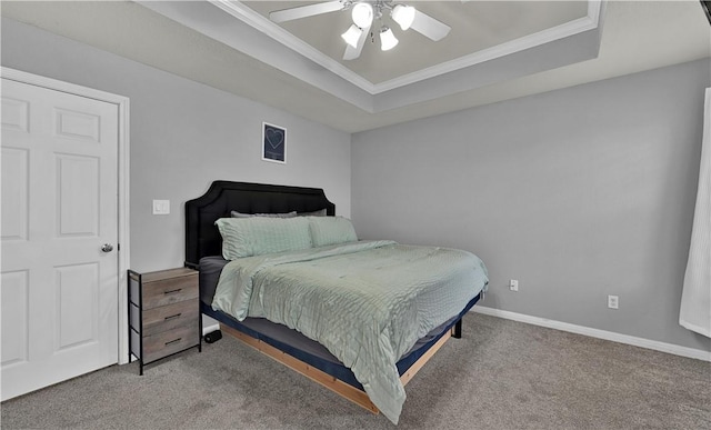 carpeted bedroom with baseboards, a raised ceiling, and ornamental molding