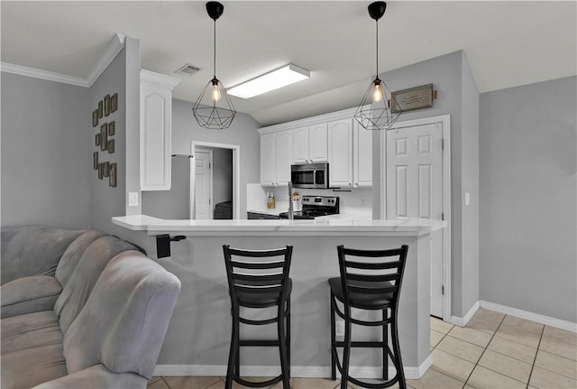 kitchen featuring a breakfast bar, a peninsula, visible vents, and stainless steel appliances