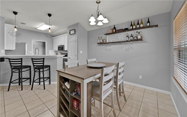 dining room featuring light tile patterned flooring, visible vents, and baseboards