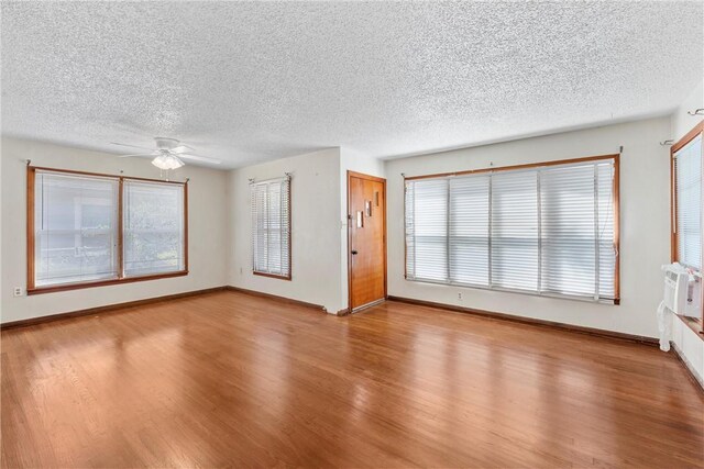 interior space featuring hardwood / wood-style floors, a textured ceiling, and ceiling fan