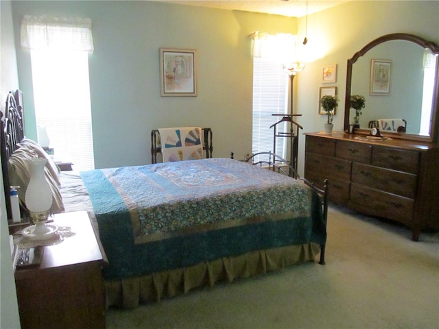 bedroom featuring light colored carpet and multiple windows