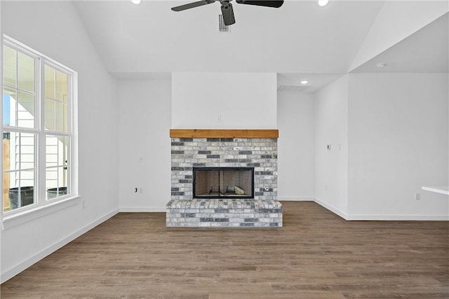 unfurnished living room featuring ceiling fan, wood-type flooring, lofted ceiling, and a fireplace