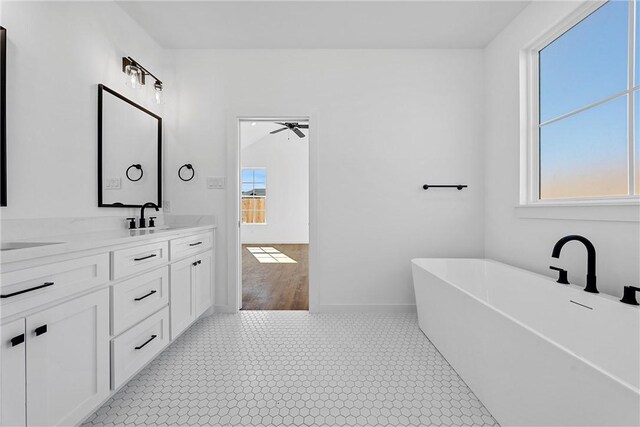 bathroom featuring a bathing tub, plenty of natural light, ceiling fan, and wood-type flooring