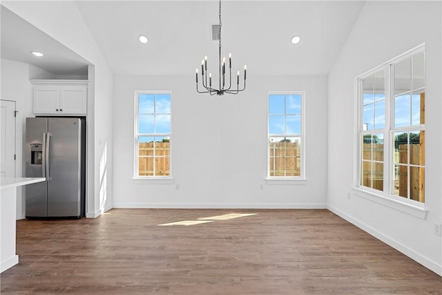 unfurnished dining area featuring hardwood / wood-style floors, plenty of natural light, and lofted ceiling